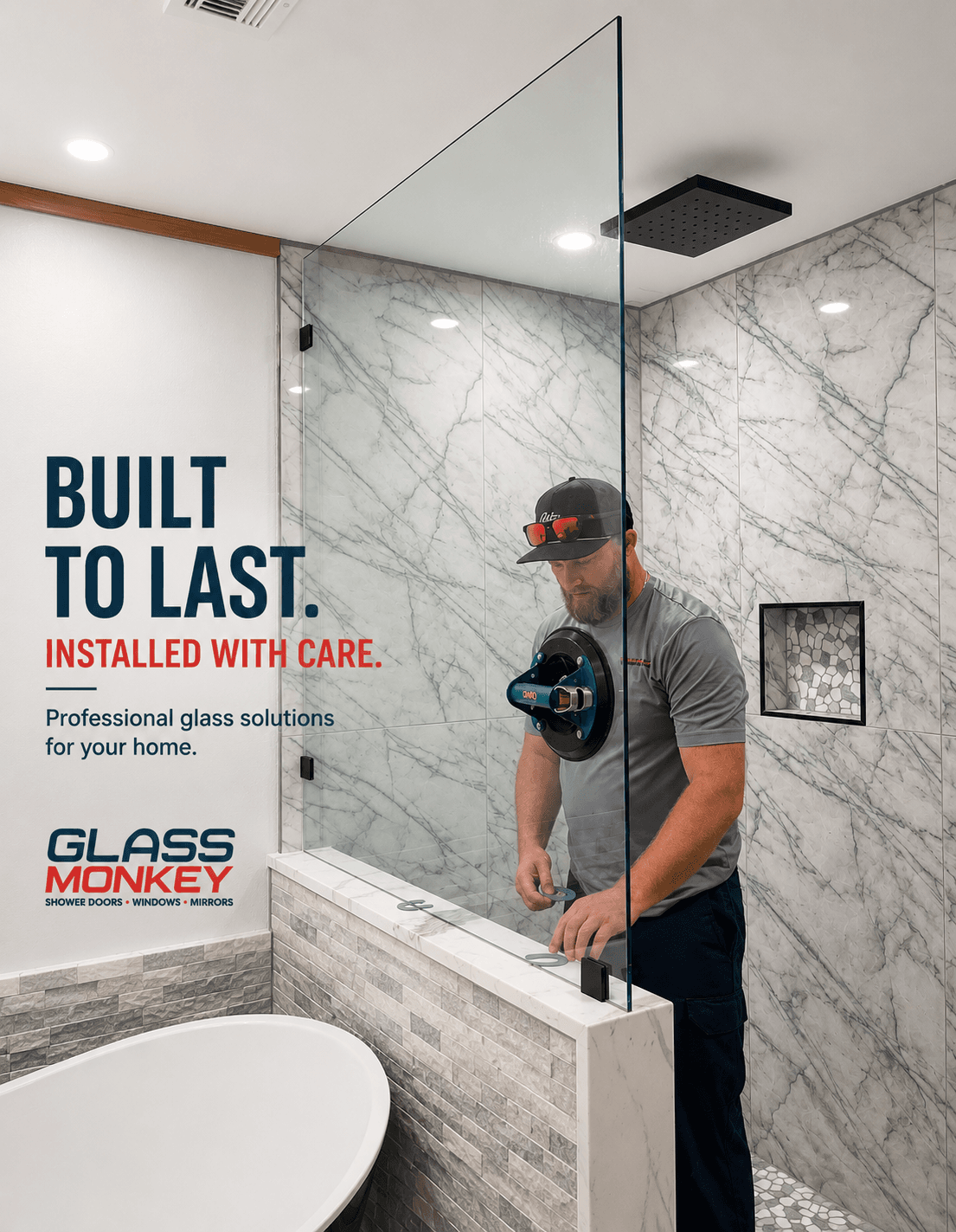 Technician using suction tools to install a glass shower panel in a marble-tiled bathroom.